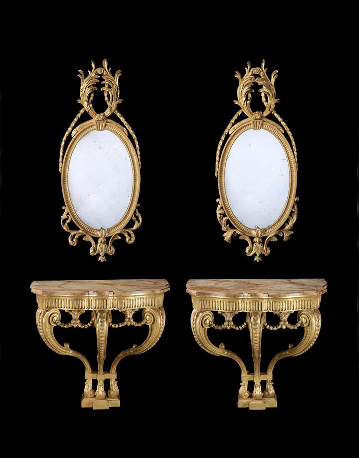 A PAIR OF GEORGE III GILTWOOD CONSOLE TABLES EN SUITE WITH A PAIR OF GILTWOOD OVAL MIRRORS